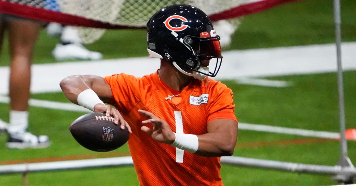 Chicago Bears quarterback Justin Fields signs baby's Bears jersey at  training camp