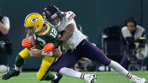 Chicago Bears defensive end Al-Quadin Muhammad (55) tackles scrambling Green Bay Packers quarterback Aaron Rodgers (12) during their football game on Sunday, September 18, 2022 at Lambeau Field. in Green Bay, Wis.