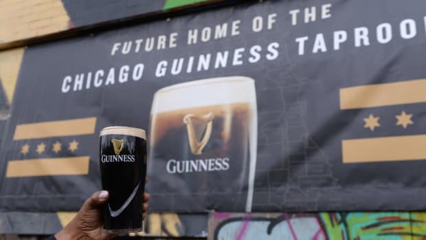 Holding a Guinness beer in front of the location of the future Chicago Guinness Taproom