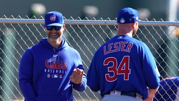 Feb 12, 2020; Mesa, Arizona, USA; Chicago Cubs manager David Ross (3) and pitcher Jon Lester (34) talk during spring training.
