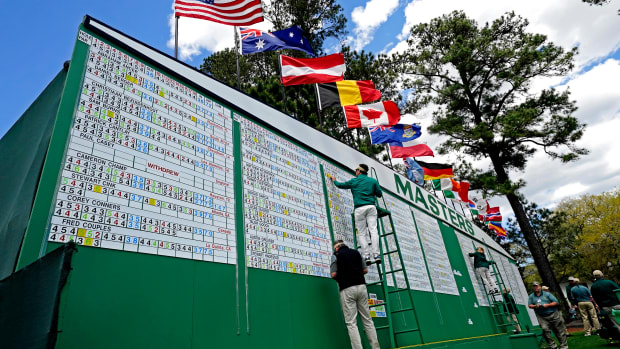 Apr 8, 2022; Augusta, Georgia, USA; Sign attendants change scores on the leaderboard during the second round of The Masters golf tournament.
