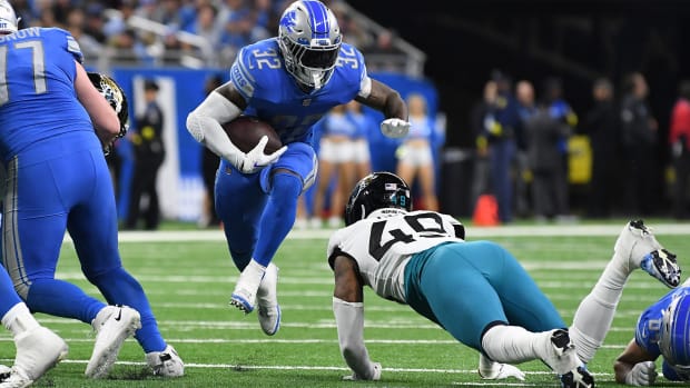 Dec 4, 2022; Detroit, Michigan, USA; Detroit Lions running back D'Andre Swift (32) leaps through a hole in the line past Jacksonville Jaguars linebacker Arden Key (49) in the fourth quarter at Ford Field.