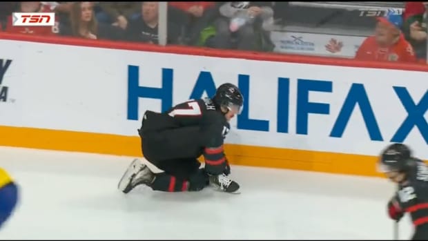 Chicago Blackhawks prospect Colton Dach falls to the ice in pain after suffering a shoulder injury in Canada's final preliminary round game against Sweden at the 2023 World Juniors.