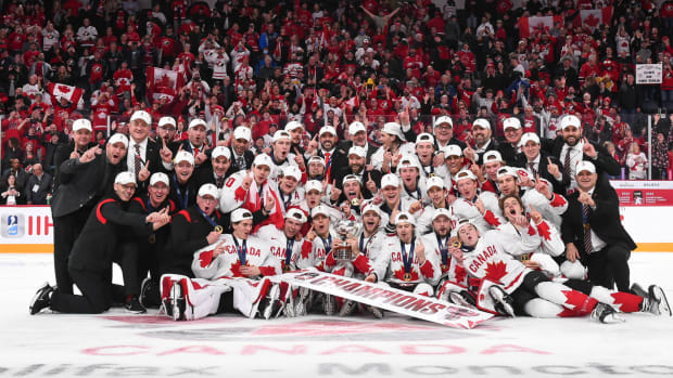 Team Canada celebrates at center ice after winning gold at the 2023 World Juniors