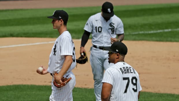 Chicago White Sox relief pitcher Drew Anderson, left, third baseman Yoan Moncada, center, and first baseman Jose Abreu, right, wait for manager Rick Renteria after Cleveland Indians' Jordan Luplow hit a two-run home run during the fourth inning of a baseball game in Chicago, Saturday, Aug. 8, 2020. (AP Photo/Nam Y. Huh)