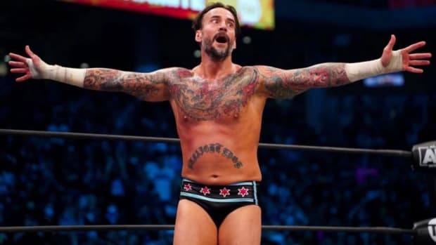 CM Punk spreads his arms in the ring at an AEW event
