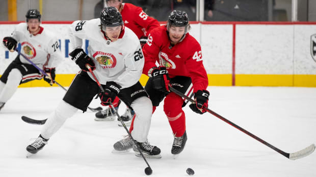 Chicago Blackhawks prospects Colton Dach and Nolan Allan race toward the puck during development camp