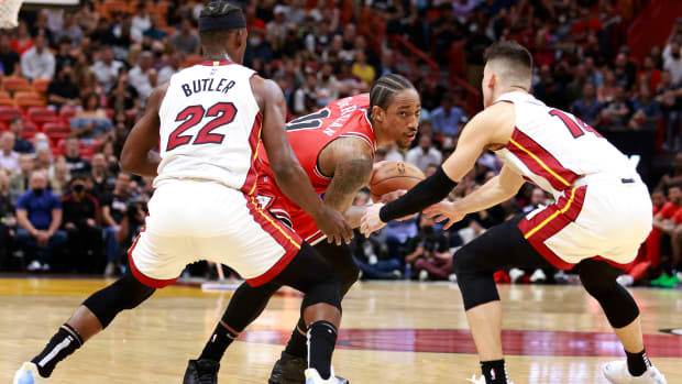 Feb 28, 2022; Miami, Florida, USA; Miami Heat forward Jimmy Butler (22) and forward Tyler Herro (14) defend Chicago Bulls forward DeMar DeRozan (11) during the first half at FTX Arena.