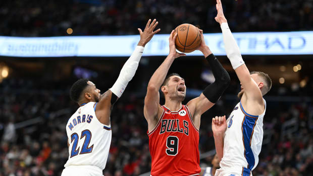 Oct 21, 2022; Washington, District of Columbia, USA; Chicago Bulls center Nikola Vucevic (9) shoots in-between Washington Wizards guard Monte Morris (22) and center Kristaps Porzingis (6) during the second half at Capital One Arena.