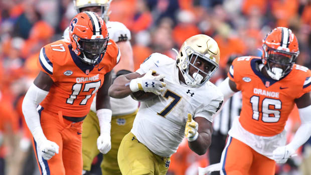 Oct 29, 2022; Syracuse, New York, USA; Notre Dame Fighting Irish running back Audric Estime (7) runs between Syracuse Orange defensive lineman Steve Linton (17) and linebacker Leon Lowery (16) in the fourth quarter at JMA Wireless Dome.