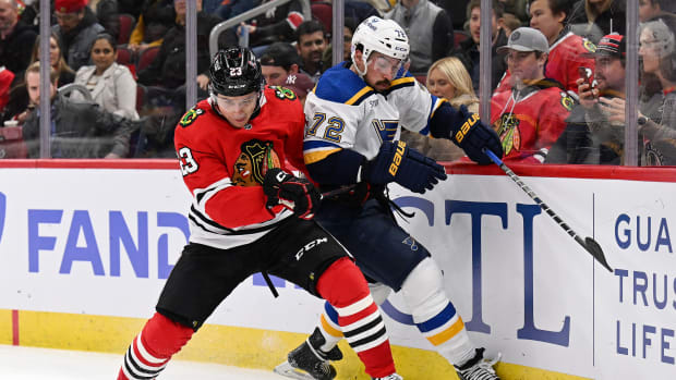 Nov 16, 2022; Chicago, Illinois, USA; Chicago Blackhawks forward Philipp Kurashev (23) battles with St. Louis Blues defenseman Justin Faulk (72) for control of the puck in the second period at the United Center.