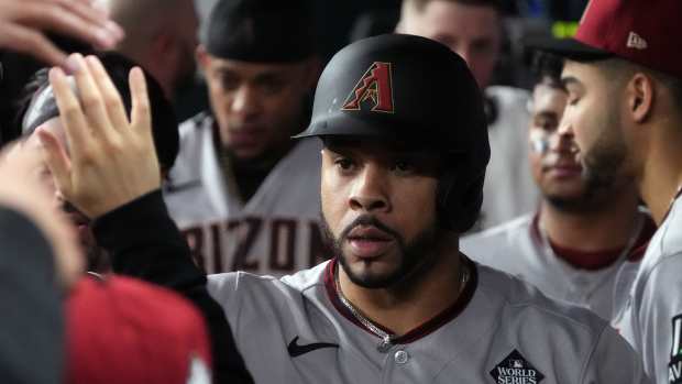 Arizona Diamondbacks outfielder Tommy Pham high fives teammates in the dugout during the 2023 World Series.