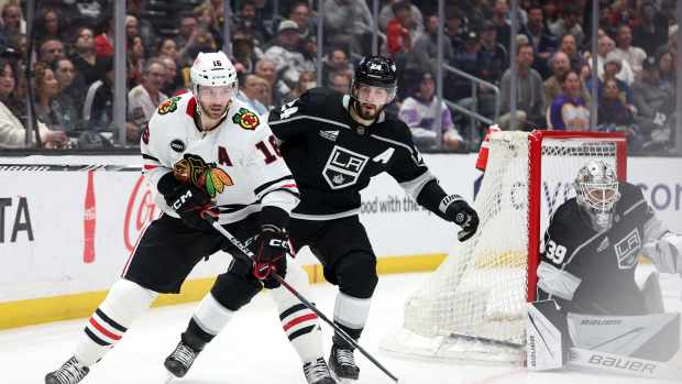 Mar 19, 2024; Los Angeles, California, USA; Chicago Blackhawks center Jason Dickinson (16) controls the puck against Los Angeles Kings center Phillip Danault (24) during the second period at Crypto.com Arena.