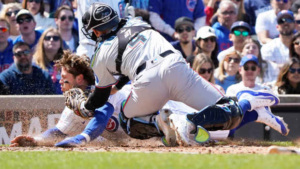 Apr 21, 2024; Chicago, Illinois, USA; Miami Marlins catcher Nick Fortes (4) tags out Chicago Cubs second baseman at home plate during the fourth inning Nico Hoerner (2) at Wrigley Field.