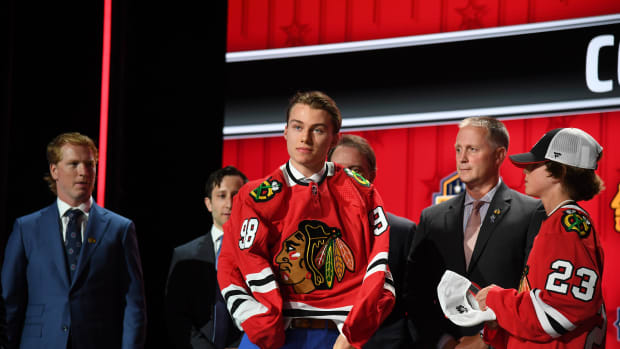 Jun 28, 2023; Nashville, Tennessee, USA; Connor Bedard puts on a Chicago Blackhawks jersey after being taken with the first pick in the 2023 NHL Draft at Bridgestone Arena.