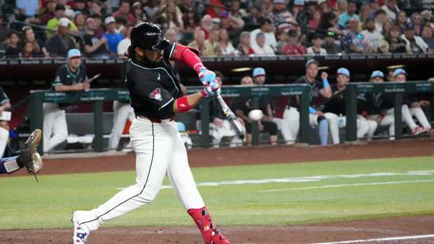 Jul 4, 2025; Phoenix, Arizona, USA; Arizona Diamondbacks third base Eugenio Suárez (28) hits a sacrifice fly RBI against the Kansas City Royals during the first inning at Chase Field.