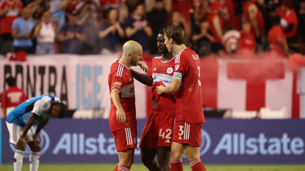 Jun 28, 2025; Chicago, Illinois, USA; Chicago Fire defender Andrew Gutman (15), midfielder Djé D'Avilla (42) and defender Jack Elliott (3) celebrate a win over Charlotte FC at Soldier Field. Mandatory Credit: Talia Sprague-Imagn Images