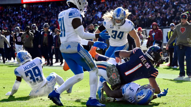 Nov 13, 2022; Chicago, Illinois, USA; Chicago Bears quarterback Justin Fields (1) scores a touchdown against Detroit Lions safety DeShon Elliott (5) linebacker Alex Anzalone (34) and safety Kerby Joseph (31) during the first half at Soldier Field. Mandatory Credit: Matt Marton-USA TODAY Sports
