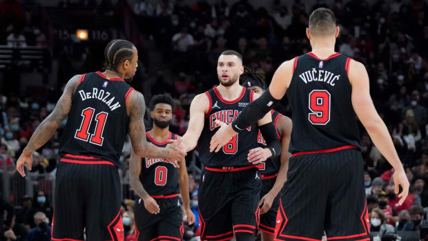 Dec 26, 2021; Chicago, Illinois, USA; Chicago Bulls guard Zach LaVine (8) celebrates a three point basket against the Indiana Pacers with forward DeMar DeRozan (11) and center Nikola Vucevic (9) during the second half at United Center.