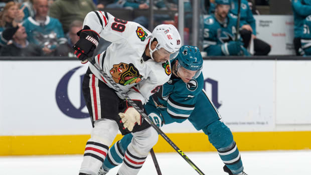 Oct 15, 2022; San Jose, California, USA; Chicago Blackhawks center Andreas Athanasiou (89) and San Jose Sharks center Nico Sturm (7) fight for control of the puck during the first period at SAP Center at San Jose.