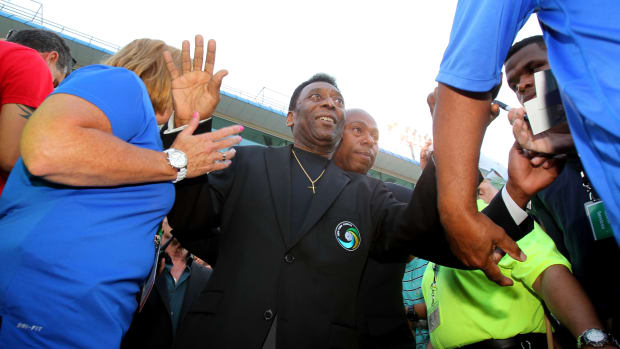 Aug 3, 2013; Hempstead, NY, USA; New York Cosmos former player Pele is led by security through the crowd during a ceremony before a match against the Fort Lauderdale Strikers at James M. Shuart Stadium.