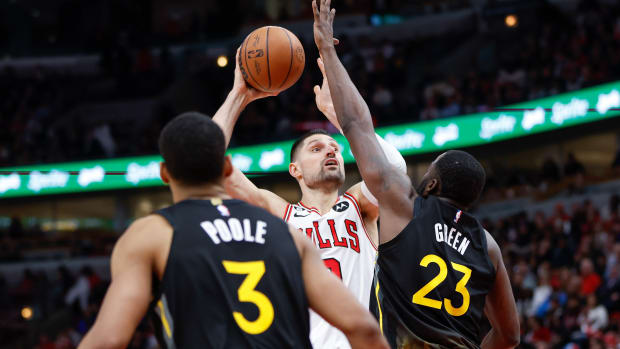 Jan 15, 2023; Chicago, Illinois, USA; Chicago Bulls center Nikola Vucevic (9) shoots against Golden State Warriors forward Draymond Green (23) during the second half of an NBA game at United Center.