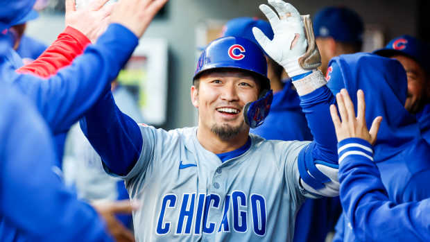 Apr 13, 2024; Seattle, Washington, USA; Chicago Cubs right fielder Seiya Suzuki (27) high-fives teammates in the dugout after hitting a solo-home run against the Seattle Mariners during the third inning at T-Mobile Park.