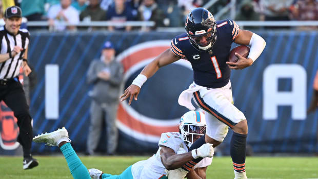 Nov 6, 2022; Chicago, Illinois, USA; Chicago Bears quarterback Justin Fields (1) runs out of the grasp of Miami Dolphins safety Eric Rowe (21) for a gain in the fourth quarter at Soldier Field. Miami defeated Chicago 35-32.