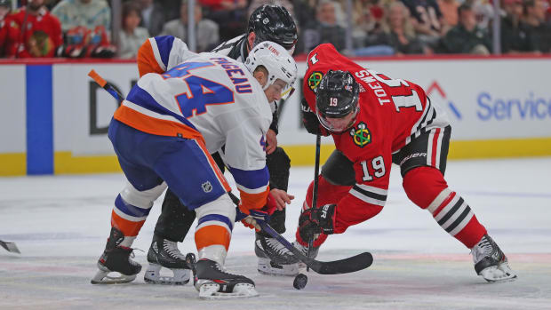 Oct 19, 2021; Chicago, Illinois, USA; Chicago Blackhawks center Jonathan Toews (19) and New York Islanders center Jean-Gabriel Pageau (44) fight for a face off during the first period at the United Center.