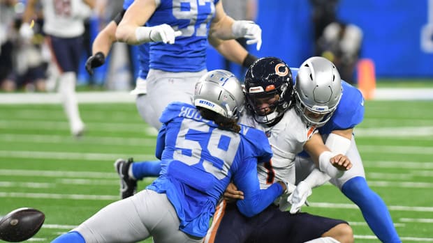 Jan 1, 2023; Detroit, Michigan, USA; Chicago Bears quarterback Justin Fields (1) fumbles the ball after being tackled by Detroit Lions linebackers James Houston (59) and Malcolm Rodriguez (44) in the second quarter at Ford Field.
