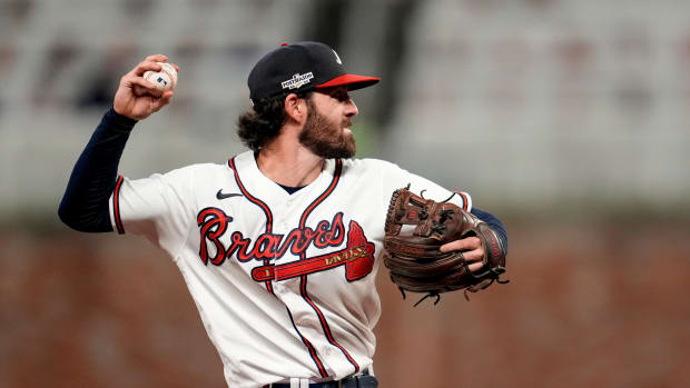 Oct 12, 2022; Atlanta, Georgia, USA; Atlanta Braves shortstop Dansby Swanson (7) fields the ball and throws out Philadelphia Phillies right fielder Nick Castellanos (8) at first base in the seventh inning during game two of the NLDS for the 2022 MLB Playoffs at Truist Park.