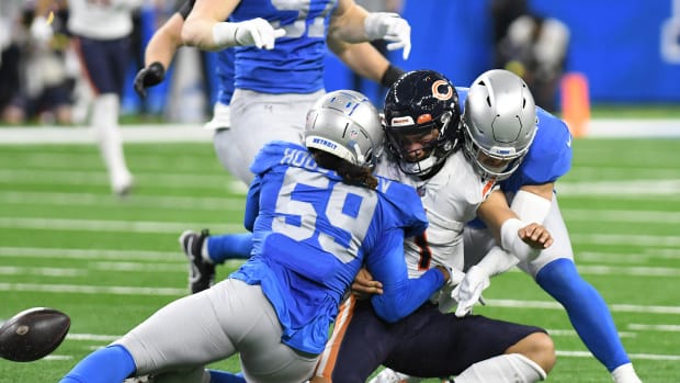Jan 1, 2023; Detroit, Michigan, USA; Chicago Bears quarterback Justin Fields (1) fumbles the ball after being tackled by Detroit Lions linebackers James Houston (59) and Malcolm Rodriguez (44) in the second quarter at Ford Field. Mandatory Credit: Lon Horwedel-USA TODAY Sports