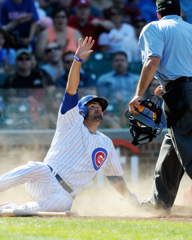 Aug 18, 2013; Chicago, IL, USA; Chicago Cubs center fielder David DeJesus (9) protests being called out as he slides through home plate during the eighth inning against the St. Louis Cardinals at Wrigley Field. Mandatory Credit: Reid Compton-USA TODAY Sports