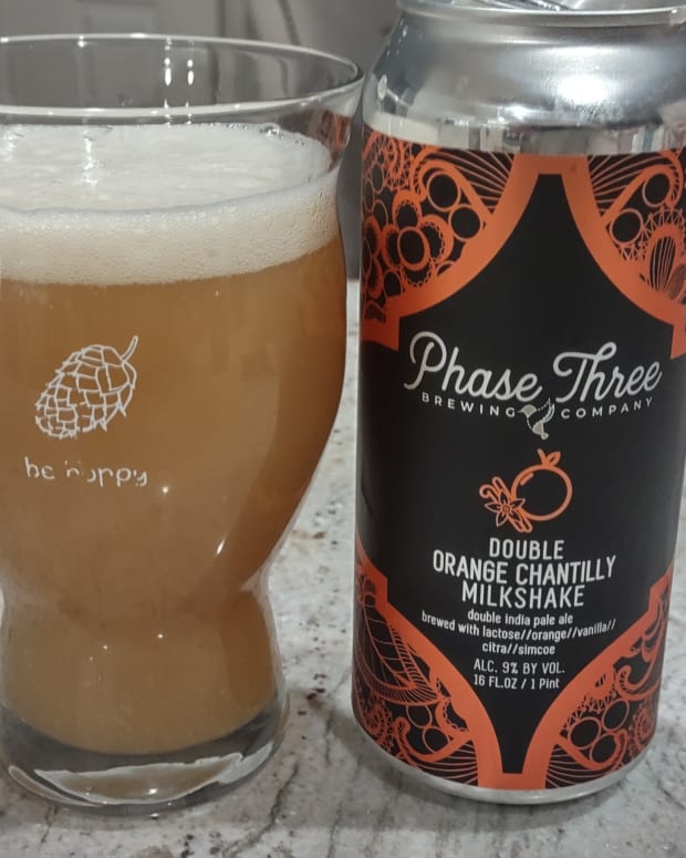 Phase Three Brewing's Double Orange Chantilly Milkshake poured into a glass next to a can