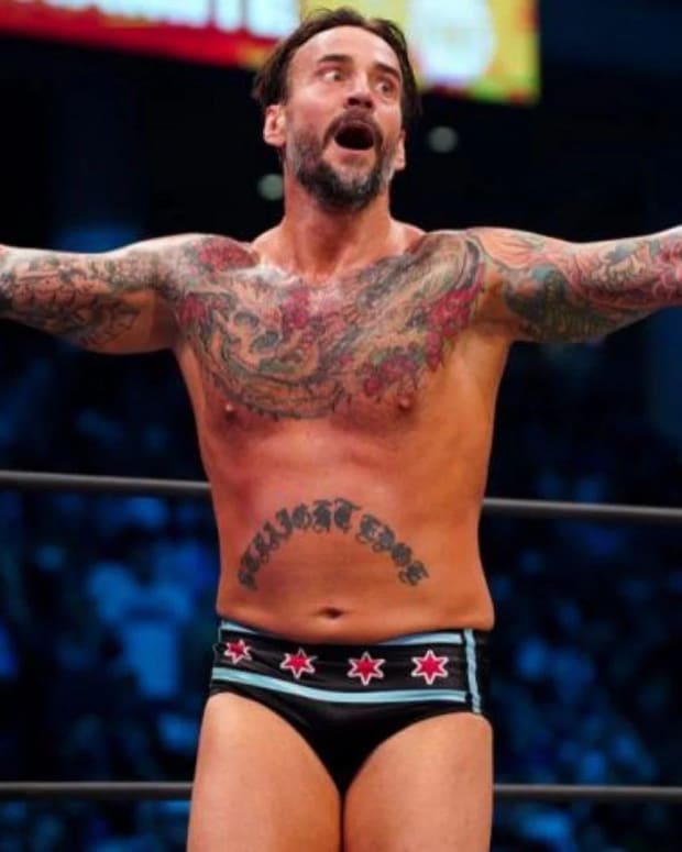 CM Punk spreads his arms in the ring at an AEW event