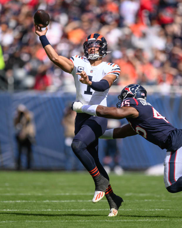 Sep 25, 2022; Chicago, Illinois, USA; Chicago Bears quarterback Justin Fields (1) passes the ball as Houston Texans defensive end Obo Okoronkwo (45) pressures in the first quarter at Soldier Field.