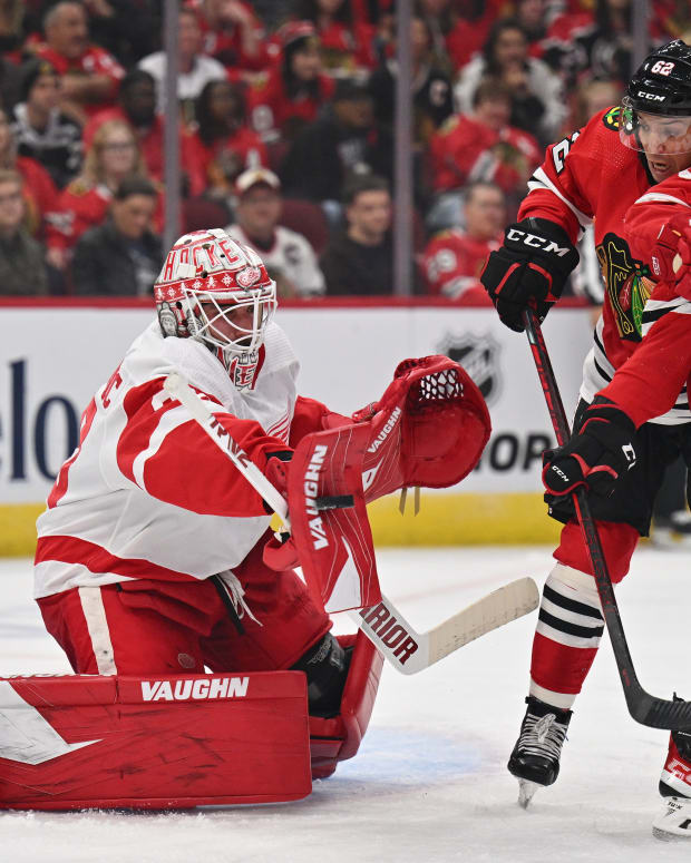 Oct 1, 2022; Chicago, Illinois, USA; Detroit Red Wings goaltender Alex Nedeljkovic (39) makes a save on a shot as Chicago Blackhawks forward Brett Seney (62) and defenseman Eemil Viro (51) battle for position in the first period at the United Center.