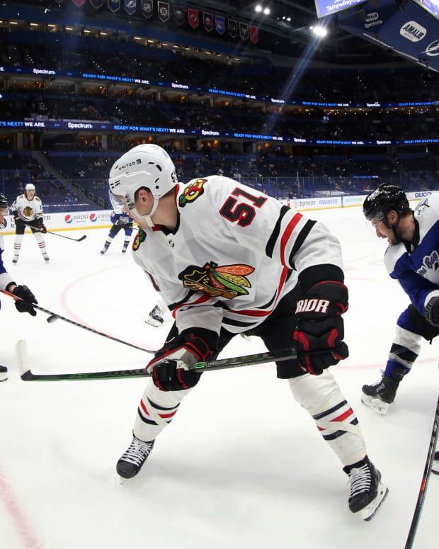 Mar 18, 2021; Tampa, Florida, USA; Chicago Blackhawks defenseman Ian Mitchell (51) passes the puck as Tampa Bay Lightning center Tyler Johnson (9) defends during the first period at Amalie Arena.