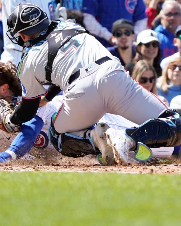 Apr 21, 2024; Chicago, Illinois, USA; Miami Marlins catcher Nick Fortes (4) tags out Chicago Cubs second baseman at home plate during the fourth inning Nico Hoerner (2) at Wrigley Field.