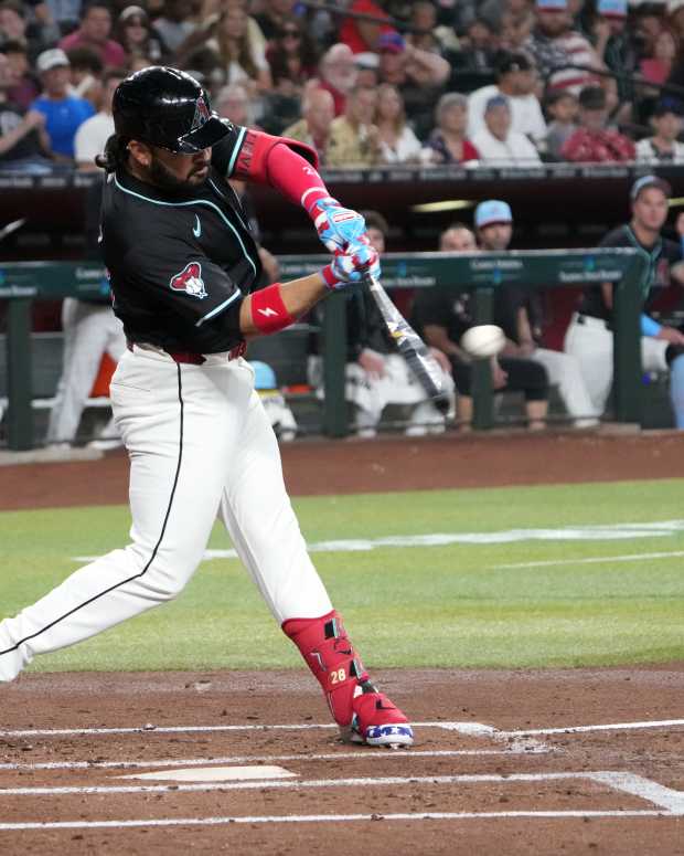 Jul 4, 2025; Phoenix, Arizona, USA; Arizona Diamondbacks third base Eugenio Suárez (28) hits a sacrifice fly RBI against the Kansas City Royals during the first inning at Chase Field.