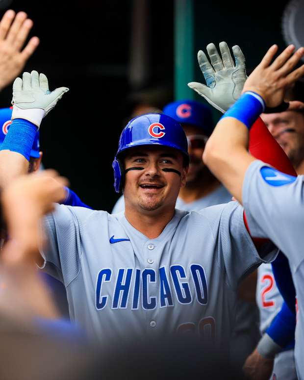 May 25, 2025; Cincinnati, Ohio, USA; Chicago Cubs catcher Reese McGuire (20) high fives teammates after hitting a solo home run in the second inning against the Cincinnati Reds at Great American Ball Park.