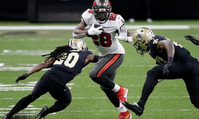 Tampa Bay Buccaneers running back Leonard Fournette (28) runs against the New Orleans Saints during the first half of an NFL divisional round playoff football game, Sunday, Jan. 17, 2021, in New Orleans. (AP Photo/Butch Dill)