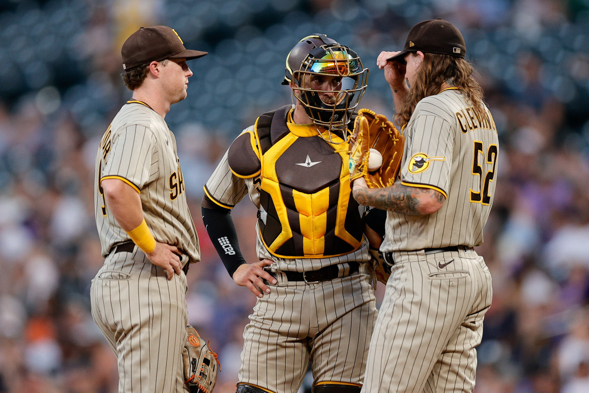 Jul 12, 2022; Denver, Colorado, USA; San Diego Padres catcher Austin Nola (26) talks with starting pitcher Mike Clevinger (52) and second baseman Jake Cronenworth (9) in the fifth inning against the Colorado Rockies at Coors Field.
