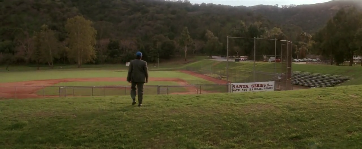 A view of an empty baseball field. We see the of Peter Panning (Robin Williams) who has missed his son's baseball game despite promising to be there.