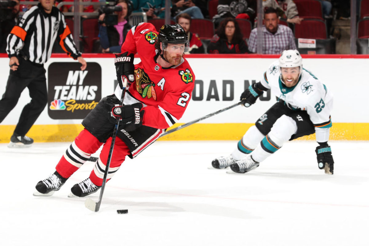 CHICAGO, IL - OCTOBER 10: Duncan Keith #2 of the Chicago Blackhawks approaches the puck against Barclay Goodrow #23 of the San Jose Sharks in the third period against at the United Center on October 10, 2019 in Chicago, Illinois. The San Jose Sharks defeated the Chicago Blackhawks 5-4.  (Photo by Chase Agnello-Dean/NHLI via Getty Images)