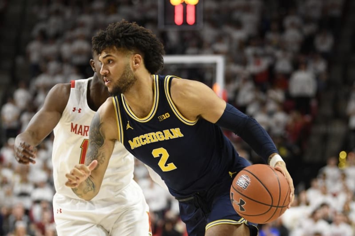 Michigan forward Isaiah Livers (2) dribbles the ball against Maryland guard Darryl Morsell, back, during the first half of an NCAA college basketball game, Sunday, March 8, 2020, in College Park, Md. (AP Photo/Nick Wass)