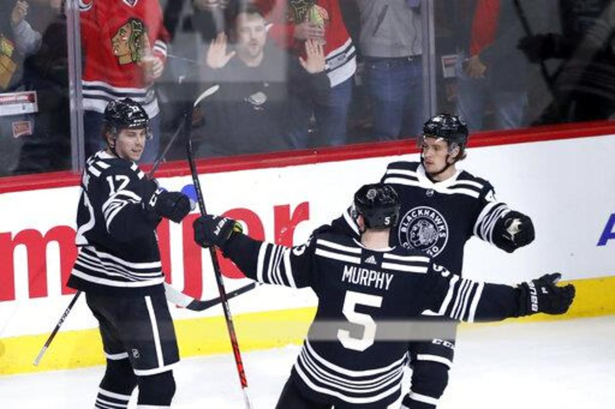 Chicago Blackhawks' Dylan Strome (17) celebrate his second goal of the game with teammates Connor Murphy (5) and Lucas Carlsson during the second period of an NHL hockey game against the Anaheim Ducks Tuesday, March 3, 2020, in Chicago. (AP Photo/Charles Rex Arbogast)