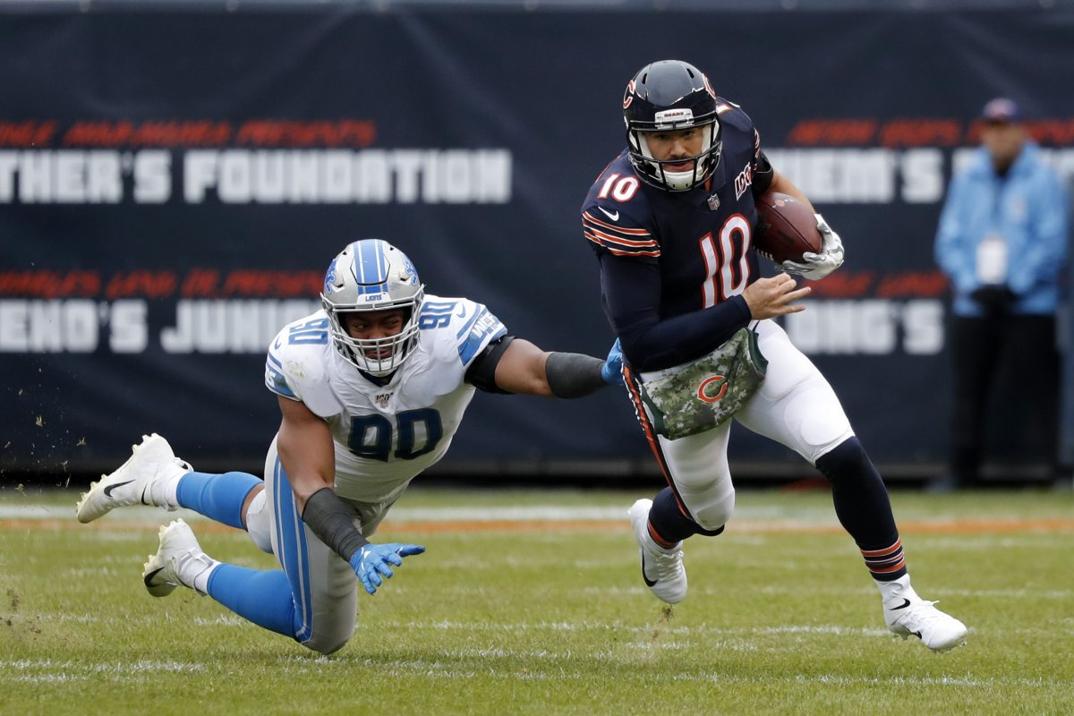 Chicago Bears quarterback Mitchell Trubisky (10) avoids a tackle byf Detroit Lions defensive end Trey Flowers (90) during the second half of an NFL football game in Chicago, Sunday, Nov. 10, 2019. (AP Photo/Charles Rex Arbogast)