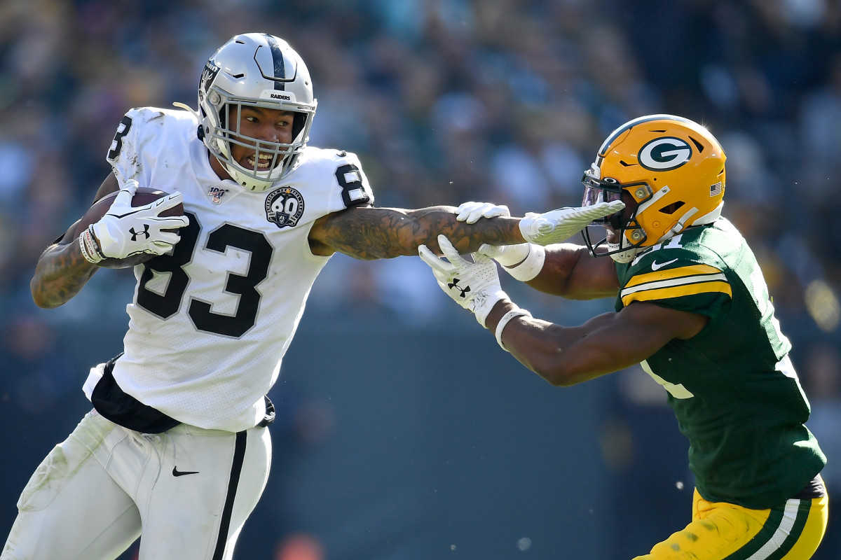 GREEN BAY, WISCONSIN - OCTOBER 20: Darren Waller #83 of the Oakland Raiders stiff arms Adrian Amos #31 of the Green Bay Packers in the second half at Lambeau Field on October 20, 2019 in Green Bay, Wisconsin. (Photo by Quinn Harris/Getty Images)