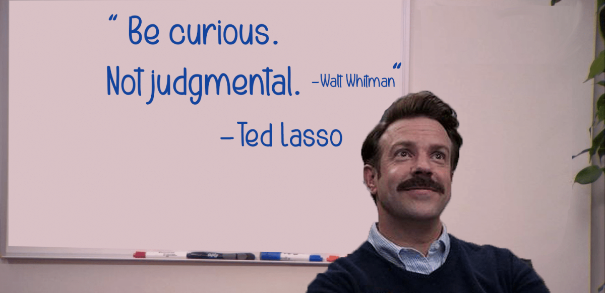 A photo of Jason Sudeikis who plays the title character on Apple TVs Ted Lasso. He is edited in front of a white board with the quote "be curious, not judgmental." The photo is based on a screenshot from the TV show The Office.